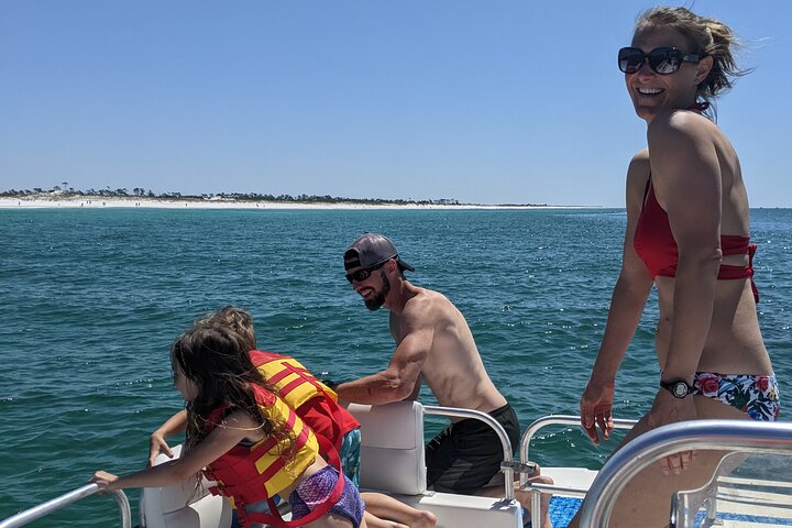 Family of four with 2 kids enjoying a luxurious private cruise while dolphin watching