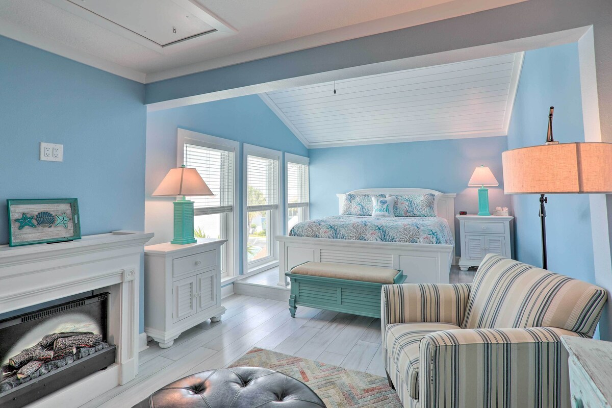 Beautiful bedroom with sky blue interiors, a queen-sized bed, couch and a digital fireplace