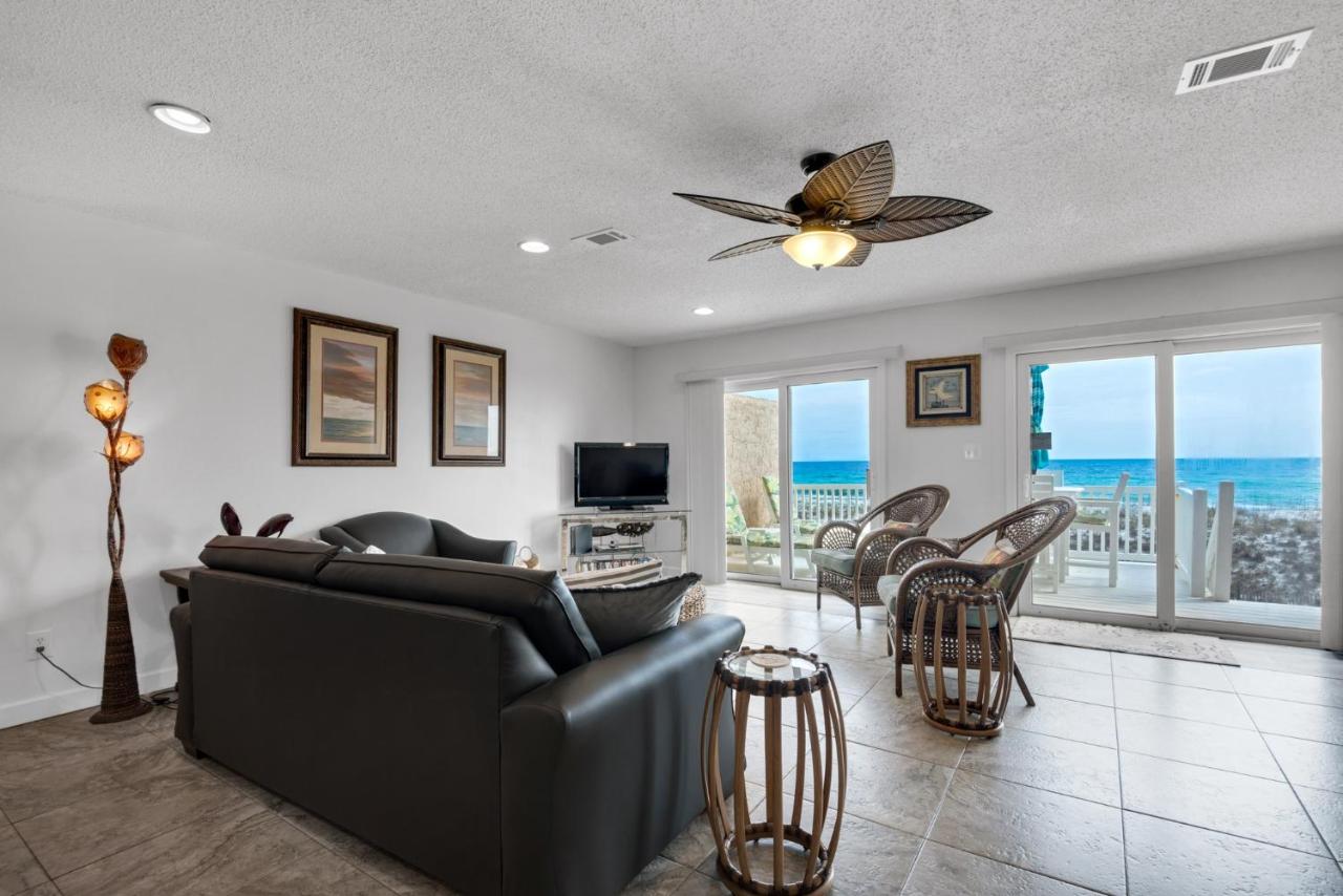 Life's A Beach Townhouse's spacious living area complete with a couch and chairs facing the beautiful beach view of Navarre Beach