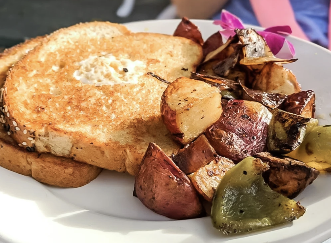 The breakfast house French toasted sandwich with grilled potatoes on the side