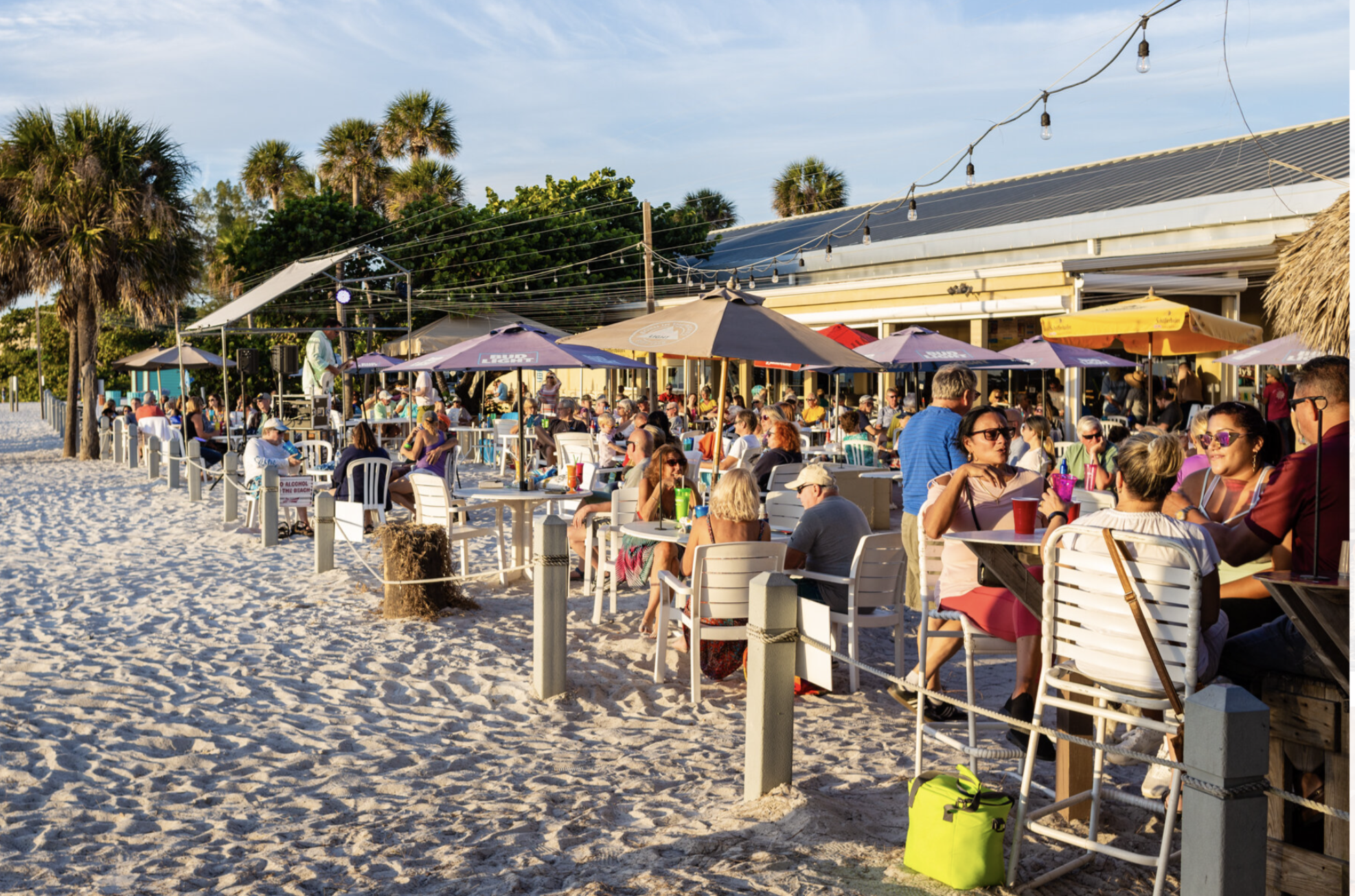 Beach dining scene with guests and visitors eating at the outdoor seating area of Anna Maria Island Beach Cafe