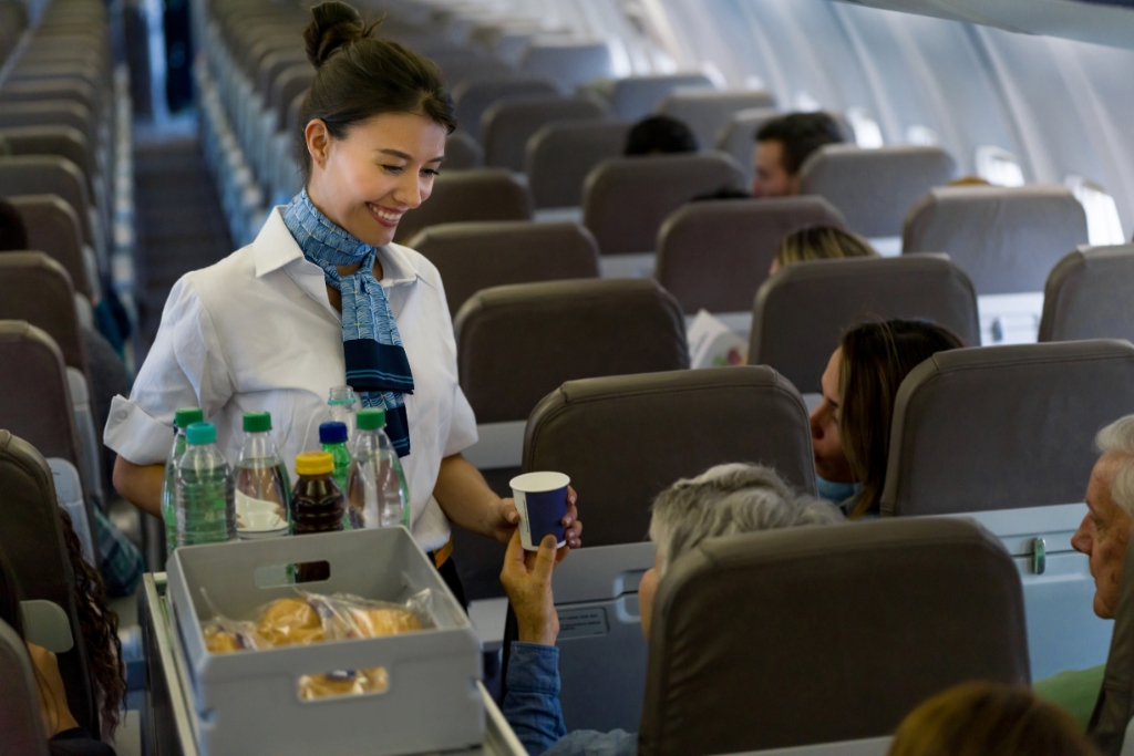 flight attendant crew serving food and beverages to passengers in the plane