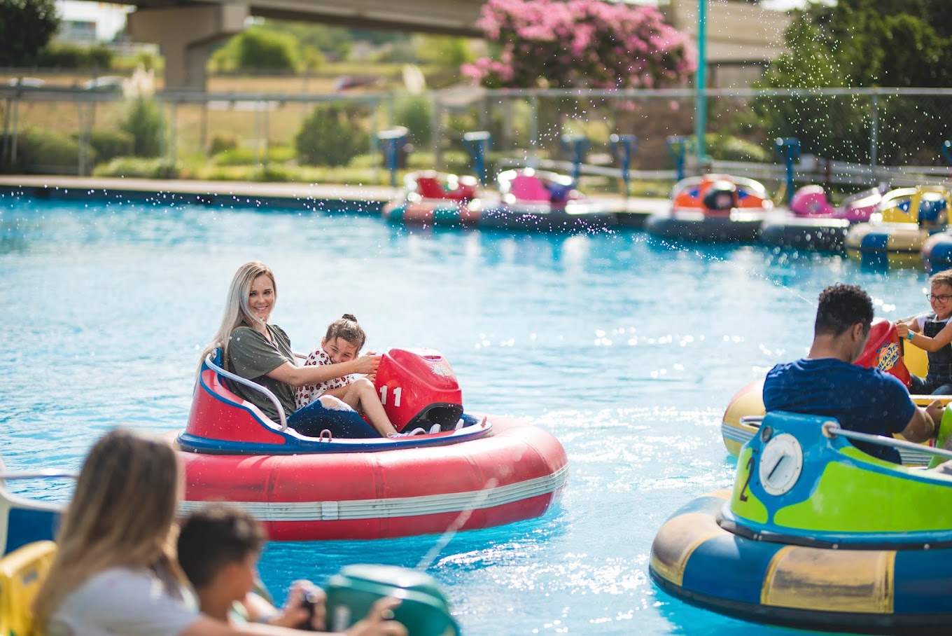 a woman and kids riding an inflatable kart in a pool