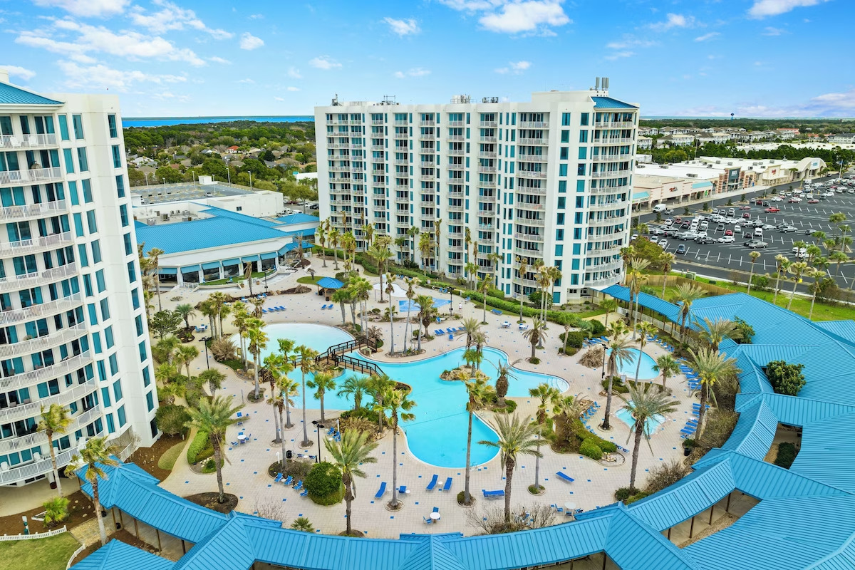 aerial view of The Palms of Destin hotel featuring the pool and the exterior of 2 towering hotel buildings