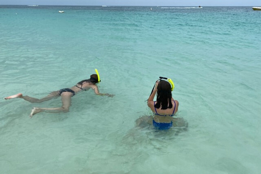 2 girls swimming and snorkeling in the blue beach waters in Aruba