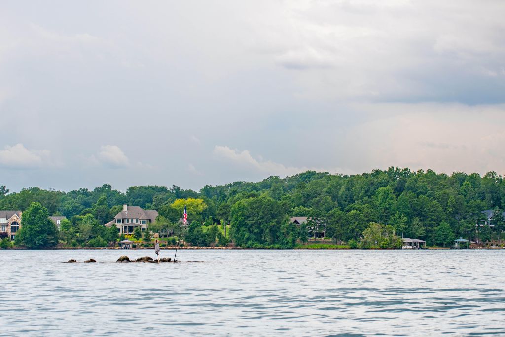 Scenic view of a lake in Seneca, South Carolina, with waterfront homes, docks, and lush green trees lining the peaceful shoreline.