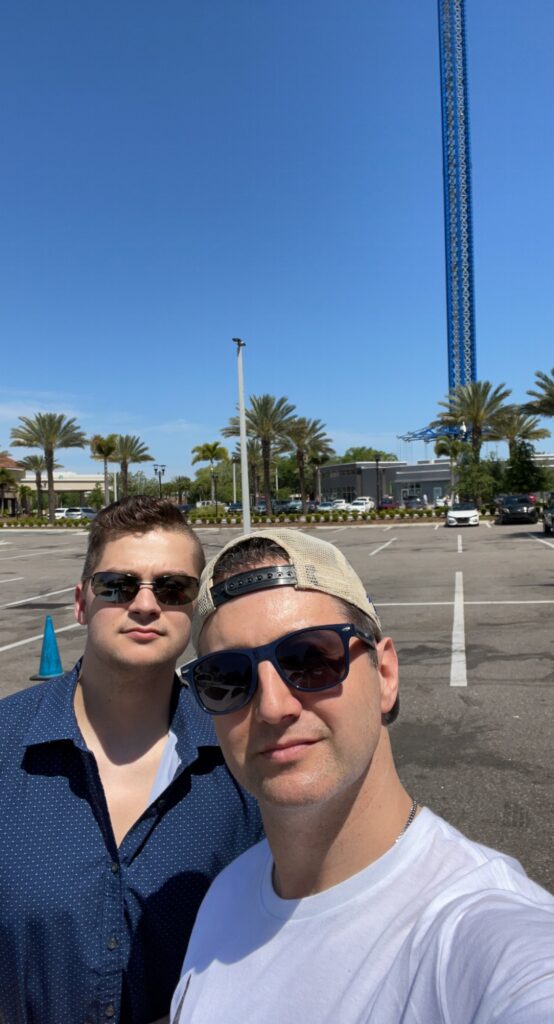 My son and I taking a picture in front of the Starflyer swing at Icon Park